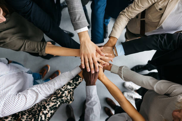 Diverse group of people stacking hands in support and unity